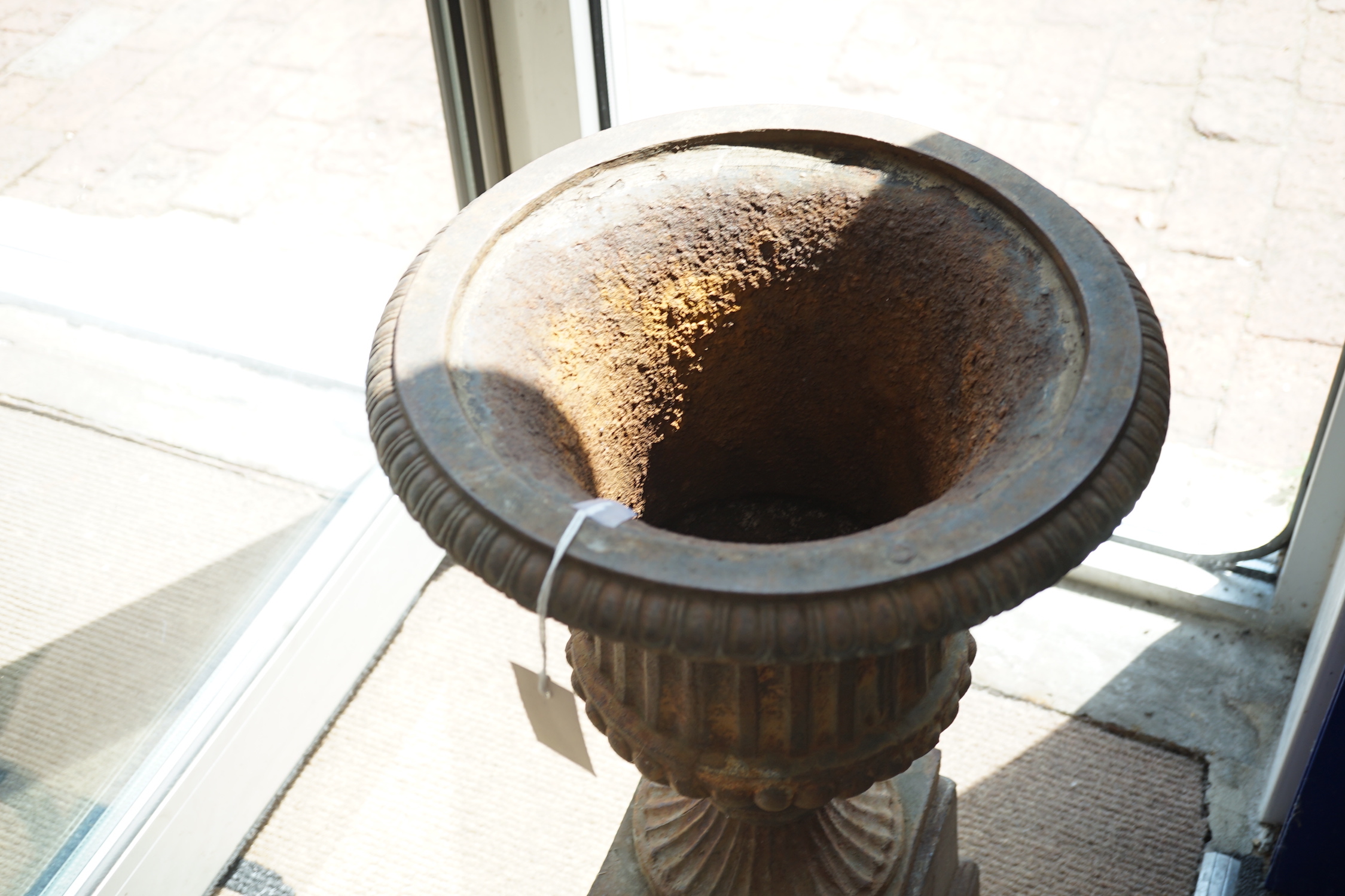 A Victorian style cast iron campana garden urn on a square plinth, diameter 38cm, height 68cm